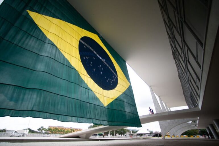 BRASILIA, BRAZIL - OCTOBER 31: Guards stand next to a Brazilian flag at the Planalto Palace entrance the day after Lula da Silva defeated incumbent Jair Bolsonaro in the presidential runoff on October 31, 2022 in Brasilia, Brazil. President of Brazil Jair Bolsonaro had not officially conceded defeat by Monday morning. (Photo by Andressa Anholete/Getty Images)