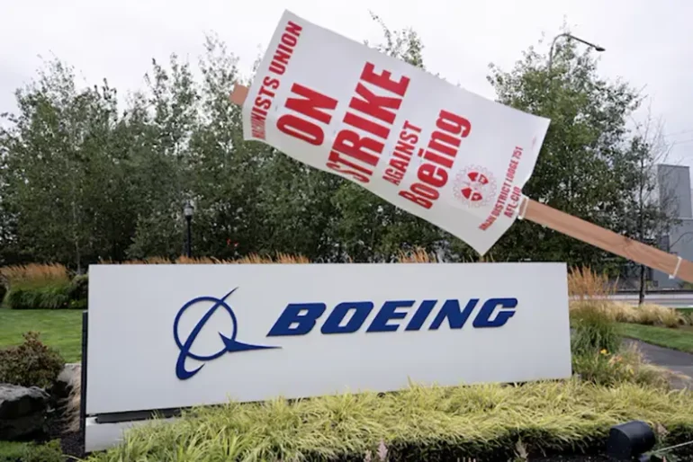 A strike sign hangs from a post near a Boeing sign as Boeing factory workers and supporters gather on a picket line during the third day of a strike near the entrance to a Boeing production facility in Renton, Washington, U.S. September 15, 2024. REUTERS/David Ryder/File Photo