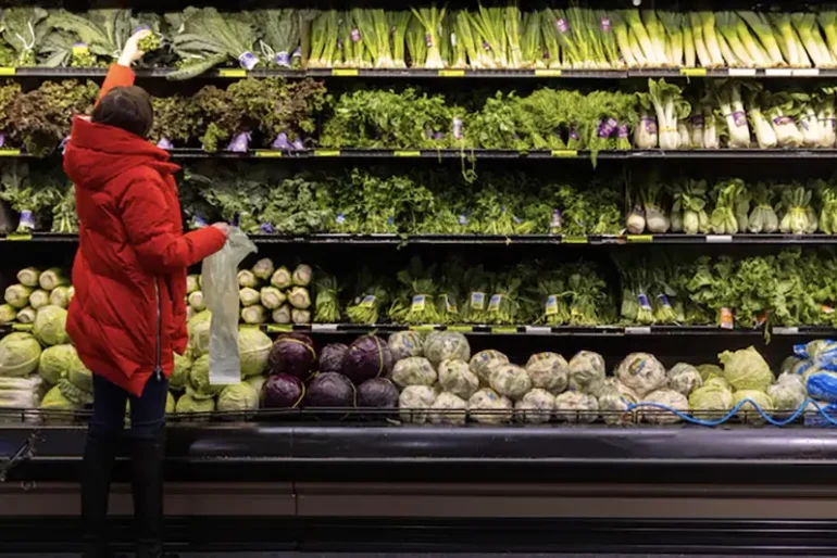 A person shops for vegetables at a supermarket in Manhattan, New York City, U.S., March 28, 2022. REUTERS/Andrew Kelly/File Photo