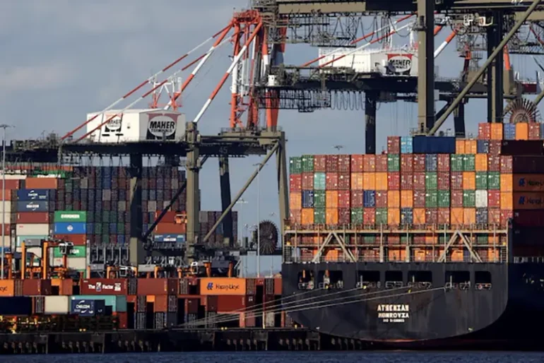 A ship stacked with shipping containers is unloaded on a pier at Port Newark, New Jersey, U.S., November 19, 2021. REUTERS/Mike Segar/File Photo