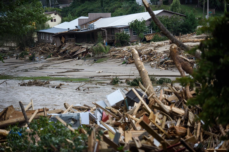 The Rocky Broad River flows into Lake Lure and overflows the town with debris from Chimney Rock, North Carolina after heavy rains from Hurricane Helene on September 28, 2024, in Lake Lure, North Carolina. Approximately six feet of debris piled on the bridge from Lake Lure to Chimney Rock, blocking access. (Photo by Melissa Sue Gerrits/Getty Images)