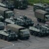 TOPSHOT - Trucks and armoured personnel carriers are seen parked at the Shenzhen Bay stadium in Shenzhen, bordering Hong Kong in China's southern Guangdong province, on August 16, 2019. - Chinese military personnel and armoured personnel carriers have mustered in large numbers across the border in Shenzhen, as Hong Kong's pro-democracy movement faces a major test this weekend as it tries to muster another huge crowd following criticism over a recent violent airport protest and as Beijing ramps up its bellicose threats. (Photo by STR / AFP) (Photo credit should read STR/AFP via Getty Images)