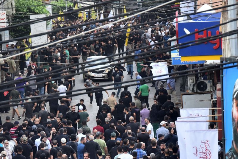 People react after a reported device explosion occurred during the funeral of people killed when hundreds of paging devices exploded in a deadly wave across Lebanon the previous day, in Beirut's southern suburbs on September 18, 2024. A second wave of device explosions killed three people in Hezbollah strongholds of Lebanon on September 18, raising fears of an all-out war between Israel and the Iran-backed militants. (Photo by Fadel ITANI / AFP) (Photo by FADEL ITANI/AFP via Getty Images)