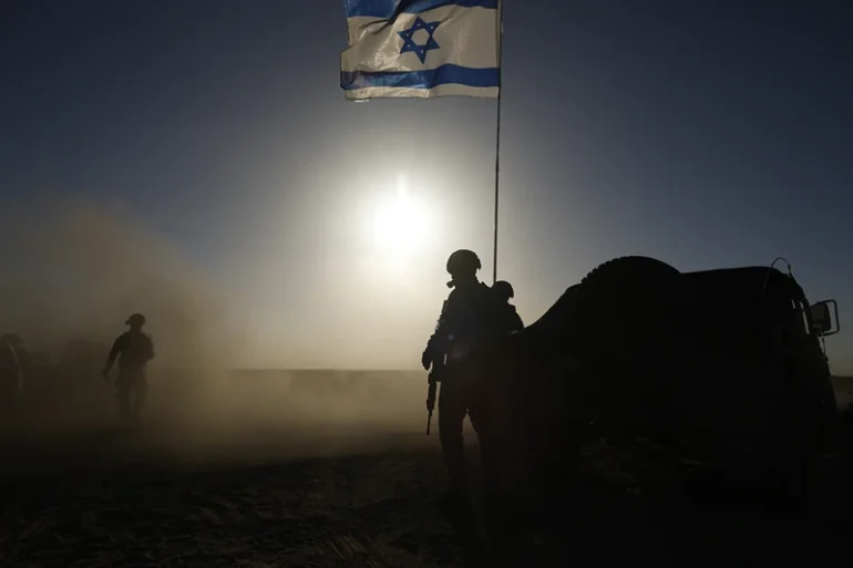 SOUTHERN ISRAEL - MARCH 4: Soldiers with the Israel Defense Forces stand near a military vehicle on March 4, 2024 in southern Israel near the border with Gaza. Over the weekend, the U.S. vice president voiced the most forceful demand yet that there be an immediate ceasefire in the conflict, imploring Hamas to agree to the a six-week pause in fighting and calling on Israel to increase the flow of aid into the territory. (Photo by Amir Levy/Getty Images)