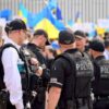 Police officers gathered near a crowd with flags.