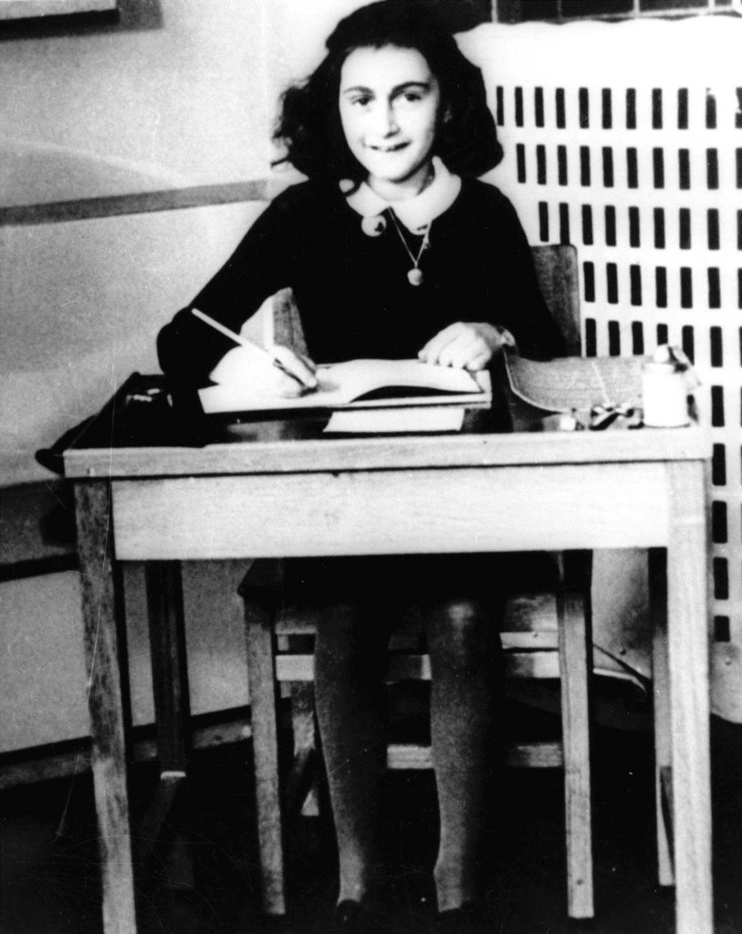 Undated photo of Anne Frank, the young Jewish girl, sitting at a desk