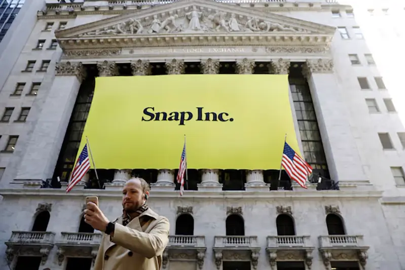 A man takes a photograph of the front of the New York Stock Exchange (NYSE) with a Snap Inc. logo hung on the front of it in New York, U.S., March 2, 2017. REUTERS/Lucas Jackson/File Photo