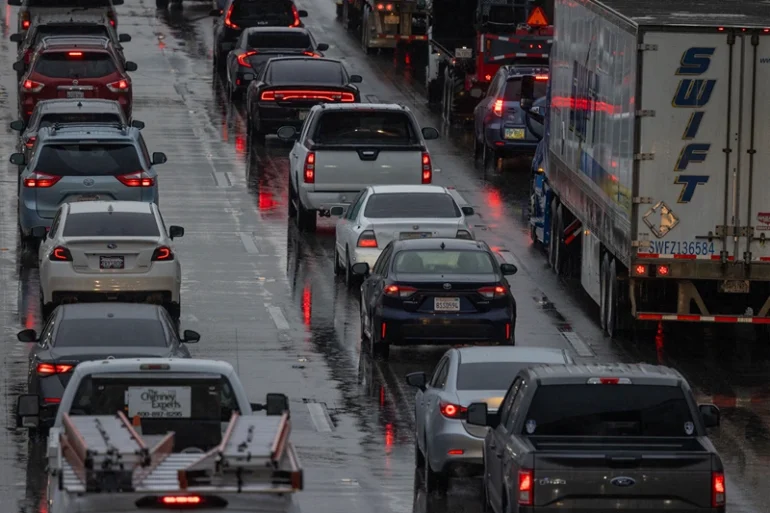 A Swift truck and cars move slowly on Interstate 5 freeway as a historic atmospheric river storm inundates Los Angeles, California, on February 6, 2024. A powerful storm lashing California has left at least three people dead and caused devastating mudslides and flooding, after dumping months' worth of rain in a single day. (Photo by DAVID MCNEW / AFP) (Photo by DAVID MCNEW/AFP via Getty Images)