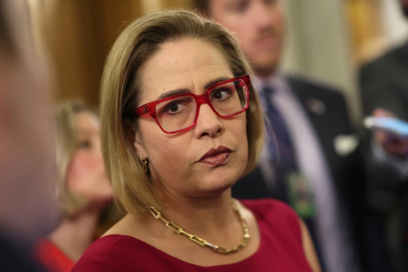 : U.S. Sen. Kyrsten Sinema (I-AZ) speaks to reporters at the U.S. Capitol on February 05, 2024 in Washington, DC. The Senate is working on bringing a bipartisan border security and immigration bill to the floor later this week for a vote. The bill, that also provides funding to Ukraine, Israel and humanitarian aid to Gaza, has received criticism from House Republicans, with Speaker Johnson saying it will be "dead on arrival." (Photo by Kevin Dietsch/Getty Images)