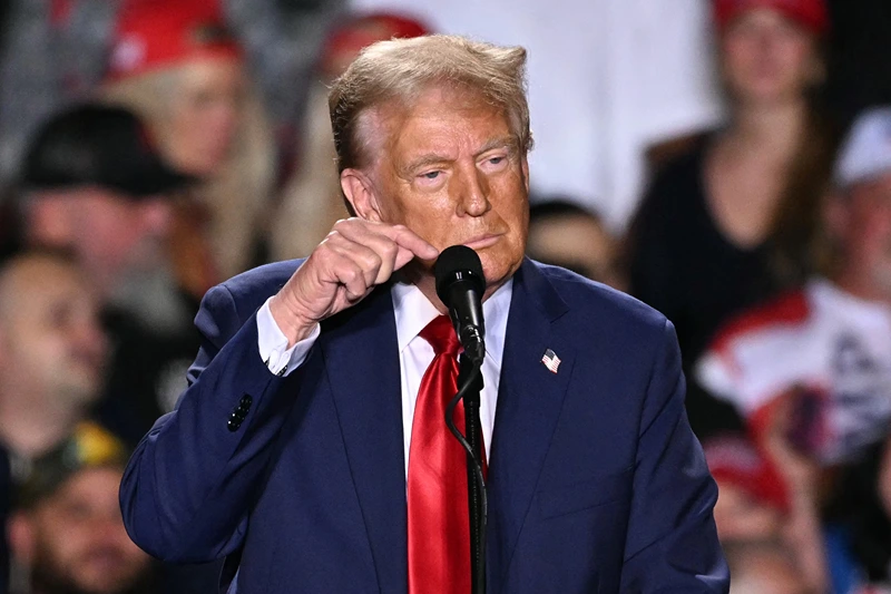 Former US President and Republican presidential candidate Donald Trump points to his microphone, which has gone out, leaving the audience unable to hear during a campaign rally at Huntington Place in Detroit, Michigan, October 18, 2024. (Photo by Jim WATSON / AFP) (Photo by JIM WATSON/AFP via Getty Images)
