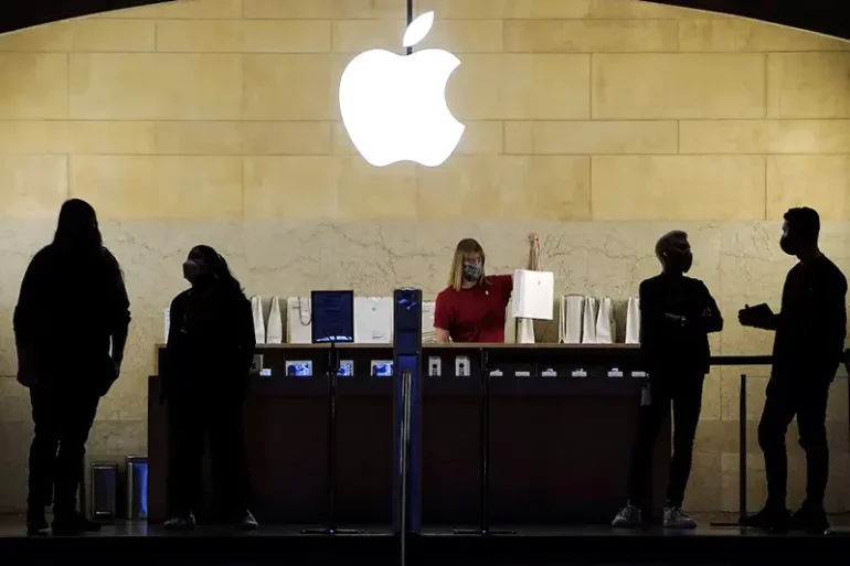 Apple employees work in an Apple Store at the Grand Central Terminal in the Manhattan borough of New York City, New York, U.S., January 4, 2022. REUTERS/Carlo Allegri/File Photo