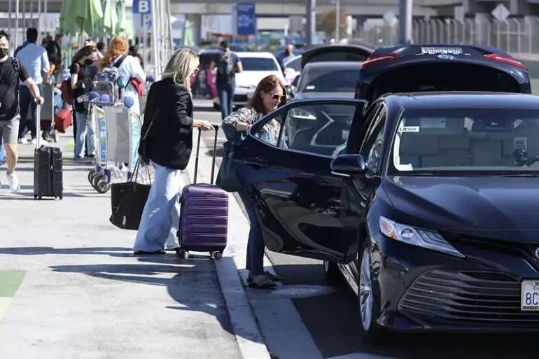 Passengers board Uber ride-share cars after arriving at Los Angeles International Airport (LAX) in Los Angeles, California, U.S. July 10, 2022. REUTERS/David Swanson/File Photo