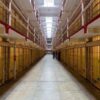 Long hallway with prison cells on both sides.