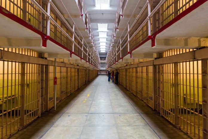 Long hallway with prison cells on both sides.