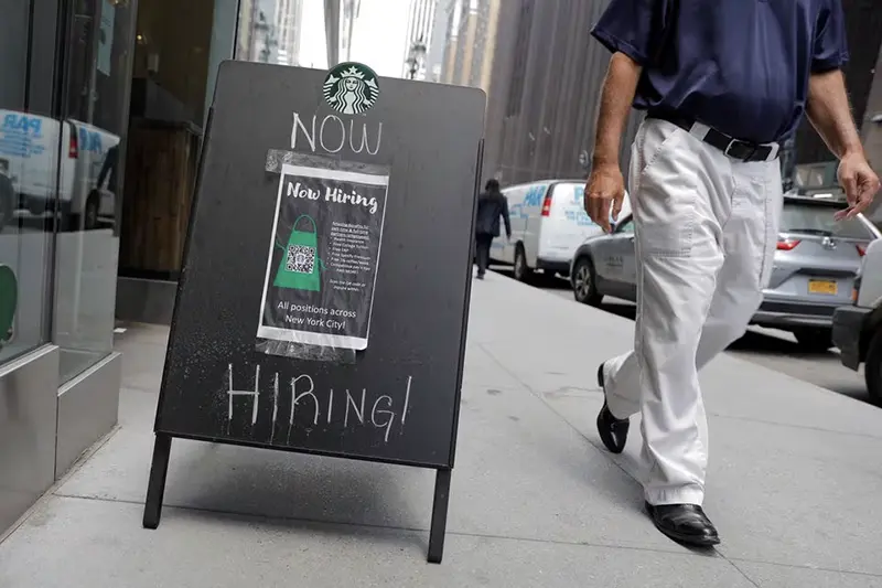 A sign advertising job openings is seen outside of a Starbucks in Manhattan, New York City, New York, U.S., May 26, 2021. REUTERS/Andrew Kelly/File Photo