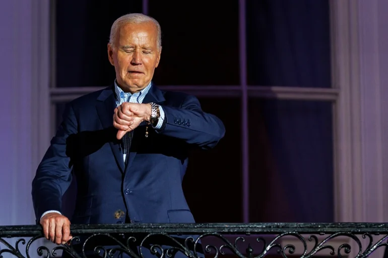 WASHINGTON, DC - JULY 04: President Joe Biden checks his watch as he steps out onto the balcony of the White House to view the fireworks over the National Mall during a 4th of July event on the South Lawn of the White House on July 4, 2024 in Washington, DC. The President is hosting the Independence Day event for members of the military and their families. (Photo by Samuel Corum/Getty Images)