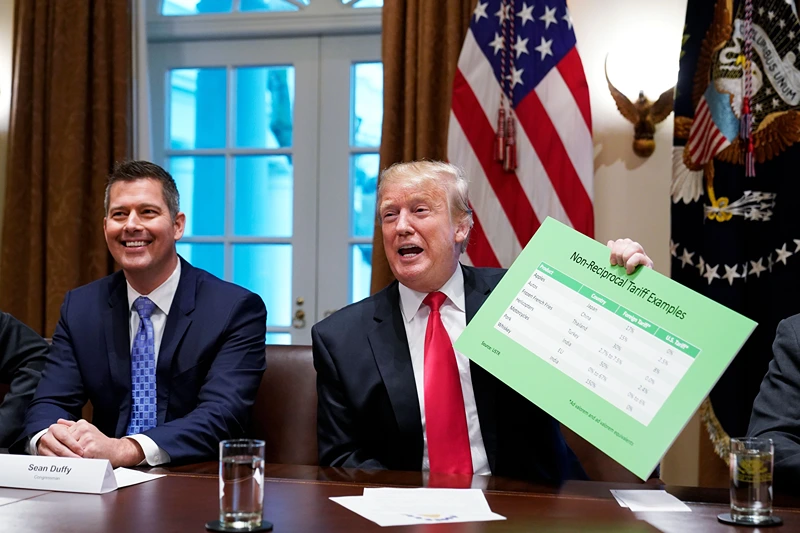 US President Donald Trump, with US Congressman Sean Duffy (L), holds a tariff table as he speaks in the Cabinet Room of the White House on January 24, 2019. - Trump spoke about the unfair trade practices at play in the world. (Photo by MANDEL NGAN / AFP) (Photo credit should read MANDEL NGAN/AFP via Getty Images)