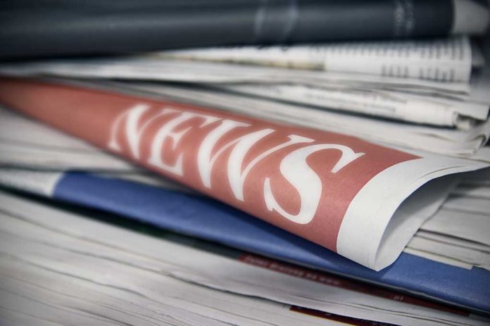 Stack of newspapers with news headline visible.