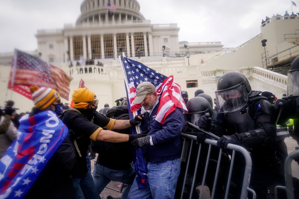 Rioters try to break through a police barrier at the Capitol on Jan. 6, 2021, in Washington