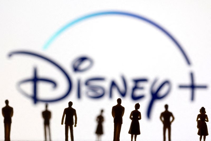 FILE PHOTO: Toy figures of people are seen in front of the displayed Disney + logo, in this illustration. REUTERS/Dado Ruvic/Illustration/File Photo