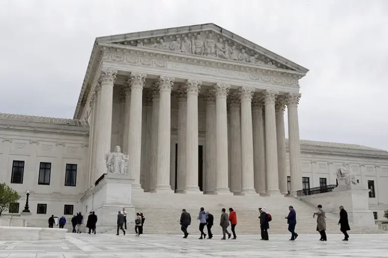 People walk across the plaza of the U.S. Supreme Court building on the first day of the court's new term in Washington, U.S. October 3, 2022. REUTERS/Jonathan Ernst/File Photo