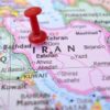 Red pushpin marking Iran on a map.