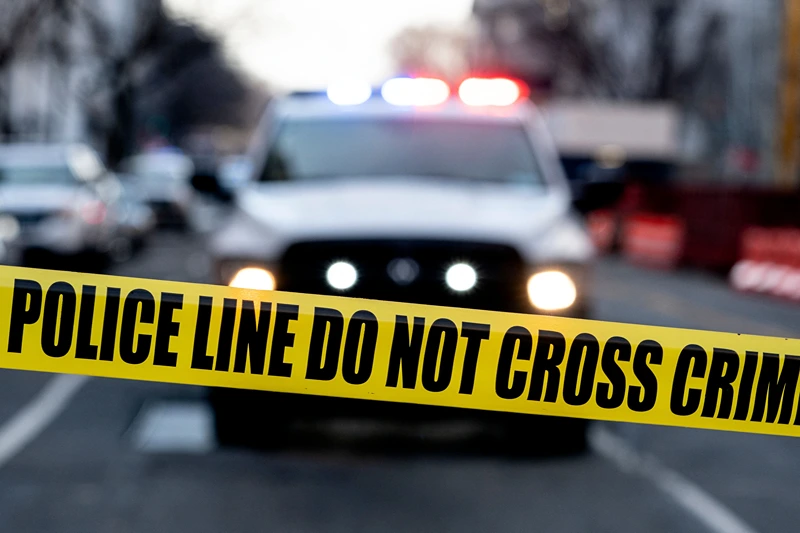 US-GUN-VIOLENCE-SHOOTING-PARKLAND Police tape is seen in front of a police vehicle as Manuel Oliver displays a banner calling on government officials to prioritize gun violence prevention from a construction crane near the White House in Washington, DC, on February 14, 2022. Oliver's son Joaquin Oliver was killed in the Parkland School shooting four years ago today. (Photo by Stefani Reynolds / AFP) (Photo by STEFANI REYNOLDS/AFP via Getty Images)