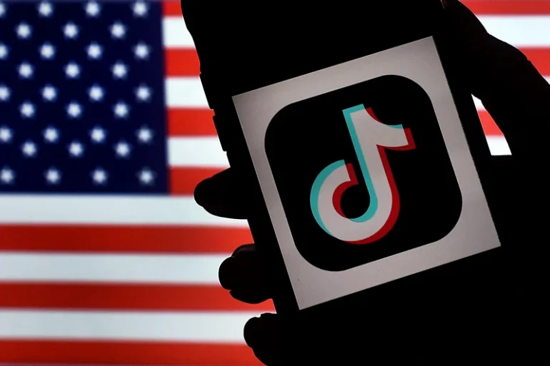 In this photo illustration, the social media application logo, TikTok is displayed on the screen of an iPhone on an American flag background on August 3, 2020 in Arlington, Virginia. - The US Senate voted on August 6, 2020, to bar TikTok from being downloaded onto US government employees' telephones, intensifying US scrutiny of the popular Chinese-owned video app. The bill passed by the Republican controlled Senate now goes to the House of Representatives, led by Democrats. (Photo by Olivier DOULIERY / AFP) (Photo by OLIVIER DOULIERY/AFP via Getty Images)