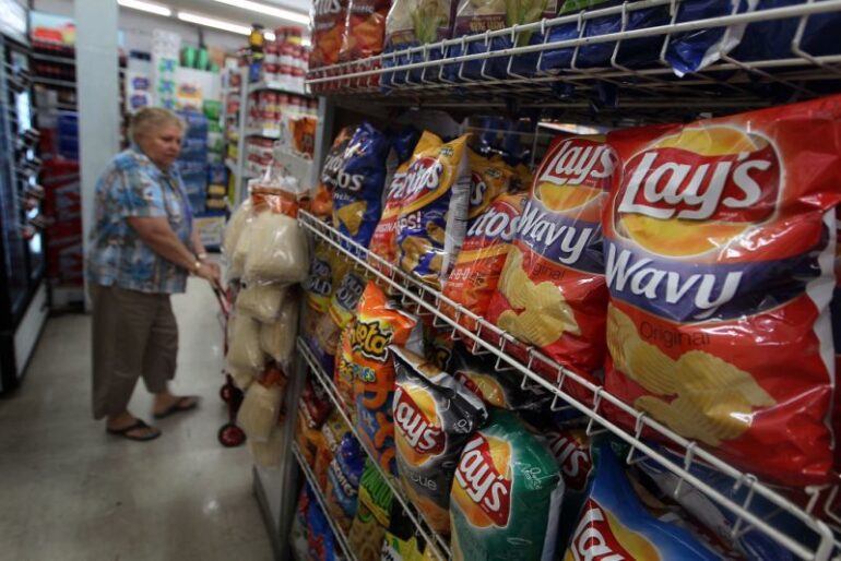 MIAMI -MARCH 22: A woman walks past bags of chips manufactured by PepsiCo Frito-Lay brand on a shelf on March 22, 2010 in Miami, Florida. PepsiCo announced plans to cut sugar, fat, and sodium in its products to address health and nutrition concerns. The maker of soft drinks including Pepsi-Cola, Gatorade also makes Frito-Lay brand snacks. (Photo by Joe Raedle/Getty Images)