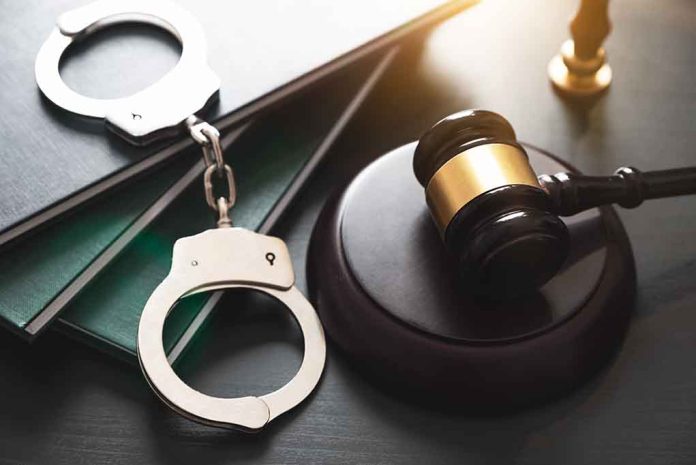 Gavel, handcuffs, and books on a table.