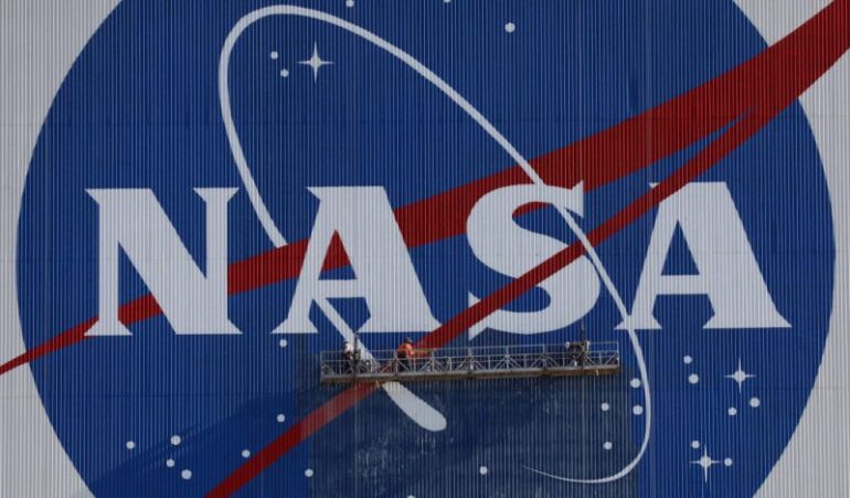 Painters refurbish the NASA logo on the Vehicle Assembly Building at the Kennedy Space Center in Florida in Florida on May 29, 2020. The faded 10-story-tall insignia was last painted 13 years ago. The SpaceX Falcon 9 rocket with the Crew Dragon capsule is rescheduled to launch to the International Space Station on May 30, carrying astronauts Bob Behnken and Doug Hurley. (Photo by Gregg Newton / AFP) (Photo by GREGG NEWTON/AFP via Getty Images)