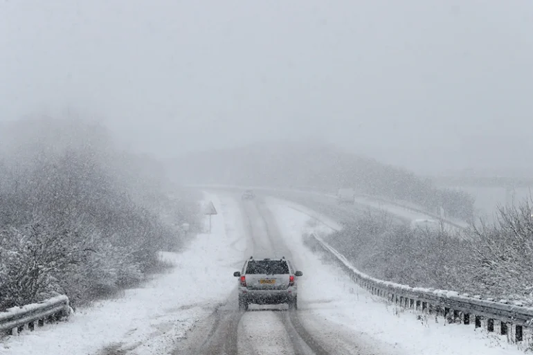 TOPSHOT - A car is driven along a slip road leading to the snow and sleet-covered A34 road a near Chievely, in Berkshire, west of London, on February 1, 2019. - Snowfall and icy conditions were expected Friday to cause travel disruption after temperatures overnight reached as low as minus 15.4C. An amber snow warning has been issued for an area west of London including parts of Oxfordshire, Hampshire and Buckinghamshire, after as much as 14cm of snow fell on south-west England. (Photo by Adrian DENNIS / AFP) (Photo by ADRIAN DENNIS/AFP via Getty Images)