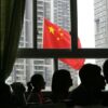 CHENGDU, CHINA - MAY 19: (CHINA OUT) Students look at a Chinese national flag flying at half-mast from a school classroom as China begins three days of national mourning for victim of the earthquake on May 19, 2008 in Chengdu, Sichuan province, China. The period of mourning will include a three minute silence which will be observed exactly one week after the earthquake hit. A major earthquake measuring 8.0 on the Richter scale, the worst in 58 years, jolted China's Sichuan Province May 12. The death toll is now estimated at over 32,000 people and is expected to rise, as 100,000 military troops continue rescue operations. (Photo by China Photos/Getty Images)