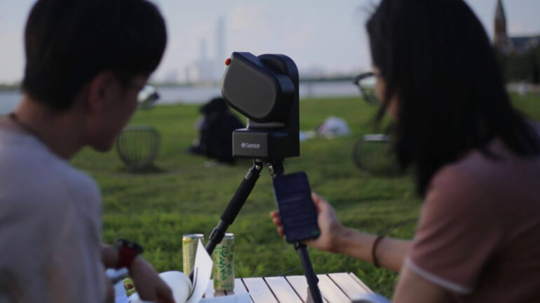 Two people operating a Seestar S50 telescope outside