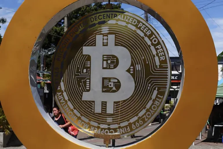 A woman passes by the Bitcoin Monument after bitcoin soared above $100,000, in Ilopango, El Salvador, December 5, 2024. REUTERS/Jose Cabezas/File Photo