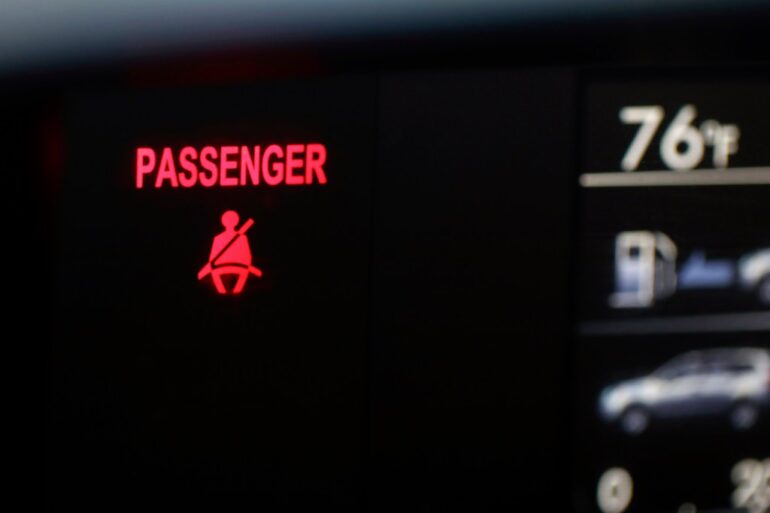 A seat belt warning sign for the right front passenger seat is displayed in a vehicle on Monday, Aug. 21, 2023.