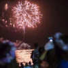 People watch a New Year's fireworks display on Waikiki beach on January 1, 2015. President Barack Obama -- still on vacation in Hawaii -- plans to spend New Year's eve with loved ones "at home," the White House said. AFP PHOTO / NICHOLAS KAMM (Photo credit should read NICHOLAS KAMM/AFP via Getty Images)