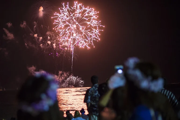 People watch a New Year's fireworks display on Waikiki beach on January 1, 2015. President Barack Obama -- still on vacation in Hawaii -- plans to spend New Year's eve with loved ones "at home," the White House said. AFP PHOTO / NICHOLAS KAMM (Photo credit should read NICHOLAS KAMM/AFP via Getty Images)