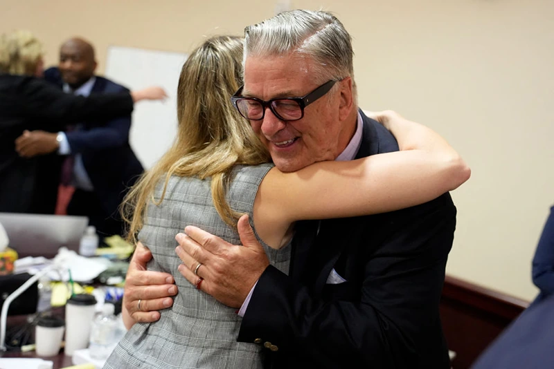 TOPSHOT - US actor Alec Baldwin hugs a member of his legal team at the conclucion of his trial on involuntary manslaughter at Santa Fe County District Court in Santa Fe, New Mexico, on July 12, 2024. Baldwin's trial for involuntary manslaughter was dismissed by a judge Friday after she ruled that key evidence over a fatal shooting on the set of "Rust" had been withheld from the defense. (Photo by RAMSAY DE GIVE / POOL / AFP) (Photo by RAMSAY DE GIVE/POOL/AFP via Getty Images)