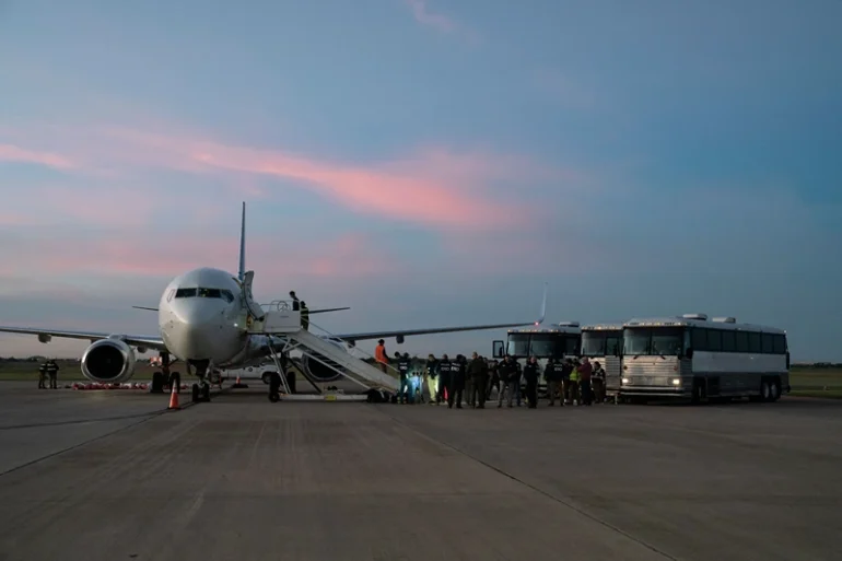 TOPSHOT - Migrants board a plane during the first deportation flight of undocumented Venezuelans from the United States to Venezuela, in Harlingen, Texas, on October 18, 2023. The United States said on October 5, 2023 it will resume deportation flights to Venezuela after a deal with Caracas, as President Joe Biden, seeking reelection, comes under pressure to halt border crossings. Washington has for years halted sending migrants back to Venezuela due to instability in the South American nation and still maintains sanctions against the government of President Nicolas Maduro. (Photo by VERONICA G. CARDENAS / AFP) (Photo by VERONICA G. CARDENAS/AFP via Getty Images)