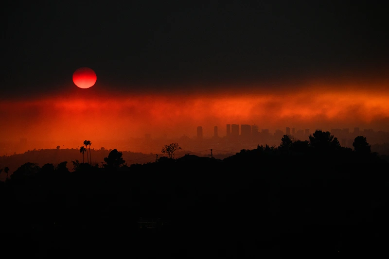 TOPSHOT - An aerial image shows smoke from wildfires including the Eaton Fire and Palisades Fire in Los Angeles, California, on January 8, 2025. At least five people have been killed in wildfires rampaging around Los Angeles, officials said on January 8, with firefighters overwhelmed by the speed and ferocity of multiple blazes. (Photo by Patrick T. Fallon / AFP) (Photo by PATRICK T. FALLON/AFP via Getty Images)