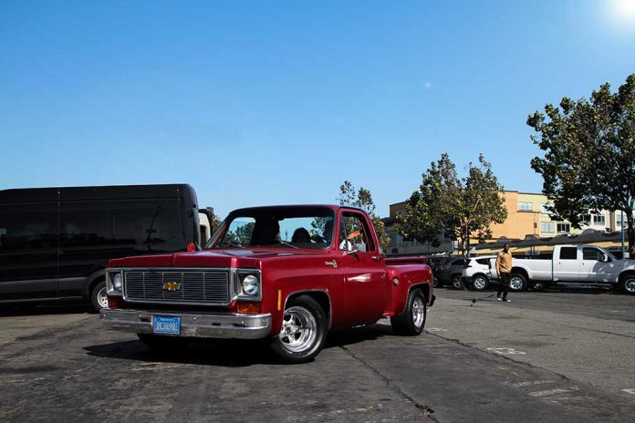 Red vintage truck parked in sunny urban setting