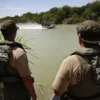 LAREDO, TX - AUGUST 07: U.S. Border Patrol agents watch colleagues motor past while patrolling for illegal immigrants in the Rio Grande River crossing into the United States August 7, 2008 near Laredo, Texas. Agents in the Laredo sector of the border travel the Rio Grande River in six 18" Diamondback airboats as part of their efforts to stop illegal immigrants, drug traffickers and terrorists from crossing illegally into the United States. Securing the nation's borders is an important topic in this year's presidential campaign. Since 9/11, the Border Patrol has grown by about a third to more than 15,000 agents. (Photo by John Moore/Getty Images)