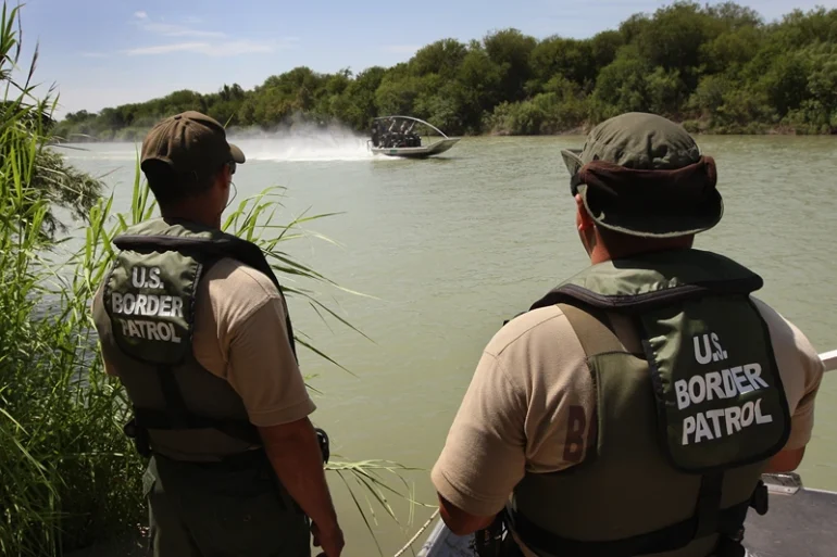 LAREDO, TX - AUGUST 07: U.S. Border Patrol agents watch colleagues motor past while patrolling for illegal immigrants in the Rio Grande River crossing into the United States August 7, 2008 near Laredo, Texas. Agents in the Laredo sector of the border travel the Rio Grande River in six 18" Diamondback airboats as part of their efforts to stop illegal immigrants, drug traffickers and terrorists from crossing illegally into the United States. Securing the nation's borders is an important topic in this year's presidential campaign. Since 9/11, the Border Patrol has grown by about a third to more than 15,000 agents. (Photo by John Moore/Getty Images)