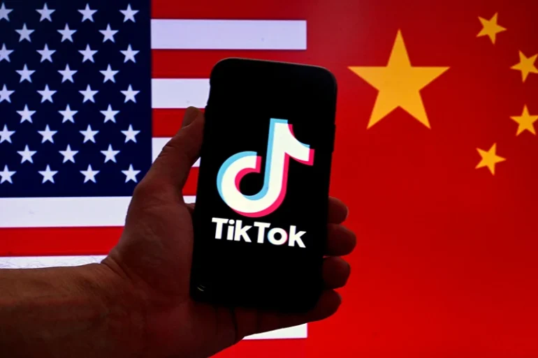 In this photo illustration the social media application logo for TikTok is displayed on the screen of an iPhone in front of a US flag and Chinese flag background in Washington, DC, on March 16, 2023. China urged the United States to stop "unreasonably suppressing" TikTok on March 16, 2023, after Washington gave the popular video-sharing app an ultimatum to part ways with its Chinese owners or face a nationwide ban. (Photo by OLIVIER DOULIERY / AFP) (Photo by OLIVIER DOULIERY/AFP via Getty Images)