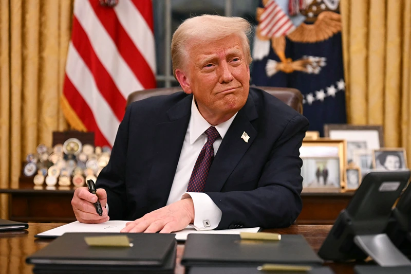 TOPSHOT - US President Donald Trump signs executive orders in the Oval Office of the White House in Washington, DC, on January 20, 2025. (Photo by Jim WATSON / AFP) (Photo by JIM WATSON/AFP via Getty Images)