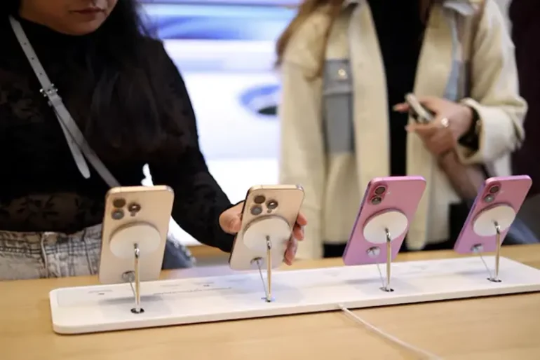 Women use Apple iPhone smartphones displayed at a store in London, Britain, October 6, 2024. REUTERS/Hollie Adams/File Photo