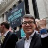 Fitbit CEO James Park posing with his device outside the New York Stock Exchange before the company's IPO in 2015