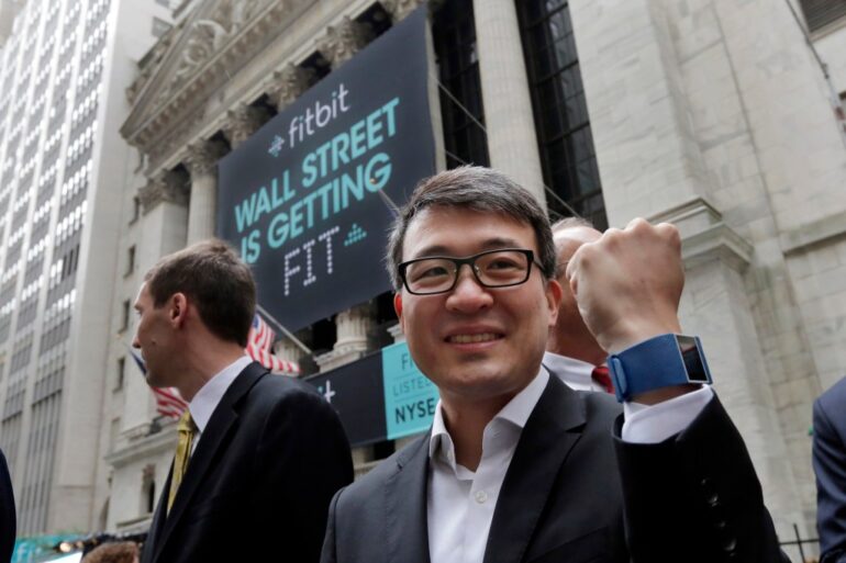 Fitbit CEO James Park posing with his device outside the New York Stock Exchange before the company's IPO in 2015