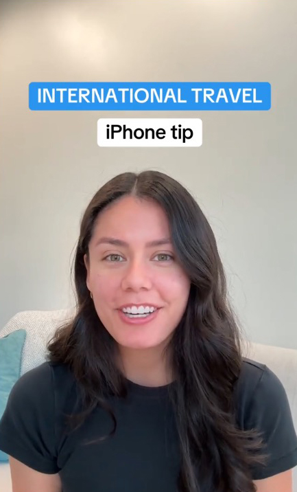 A woman explaining the new built-in currency converter feature on her iPhone, perfect for international travel